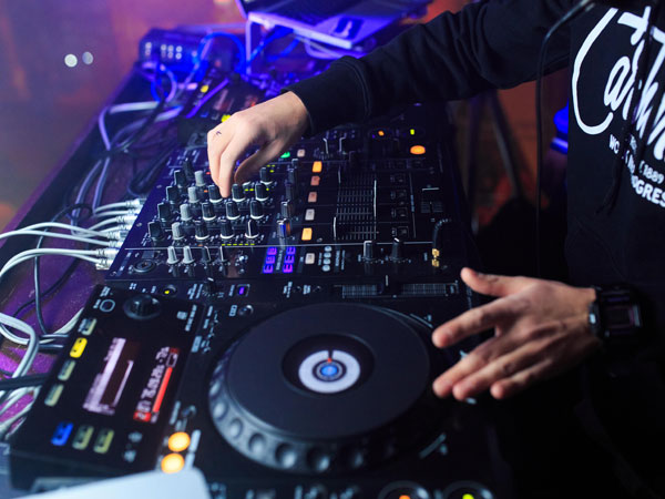 DJ playing music at modern turntable and mixer